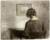A woman sat at a writing desk with her back to us