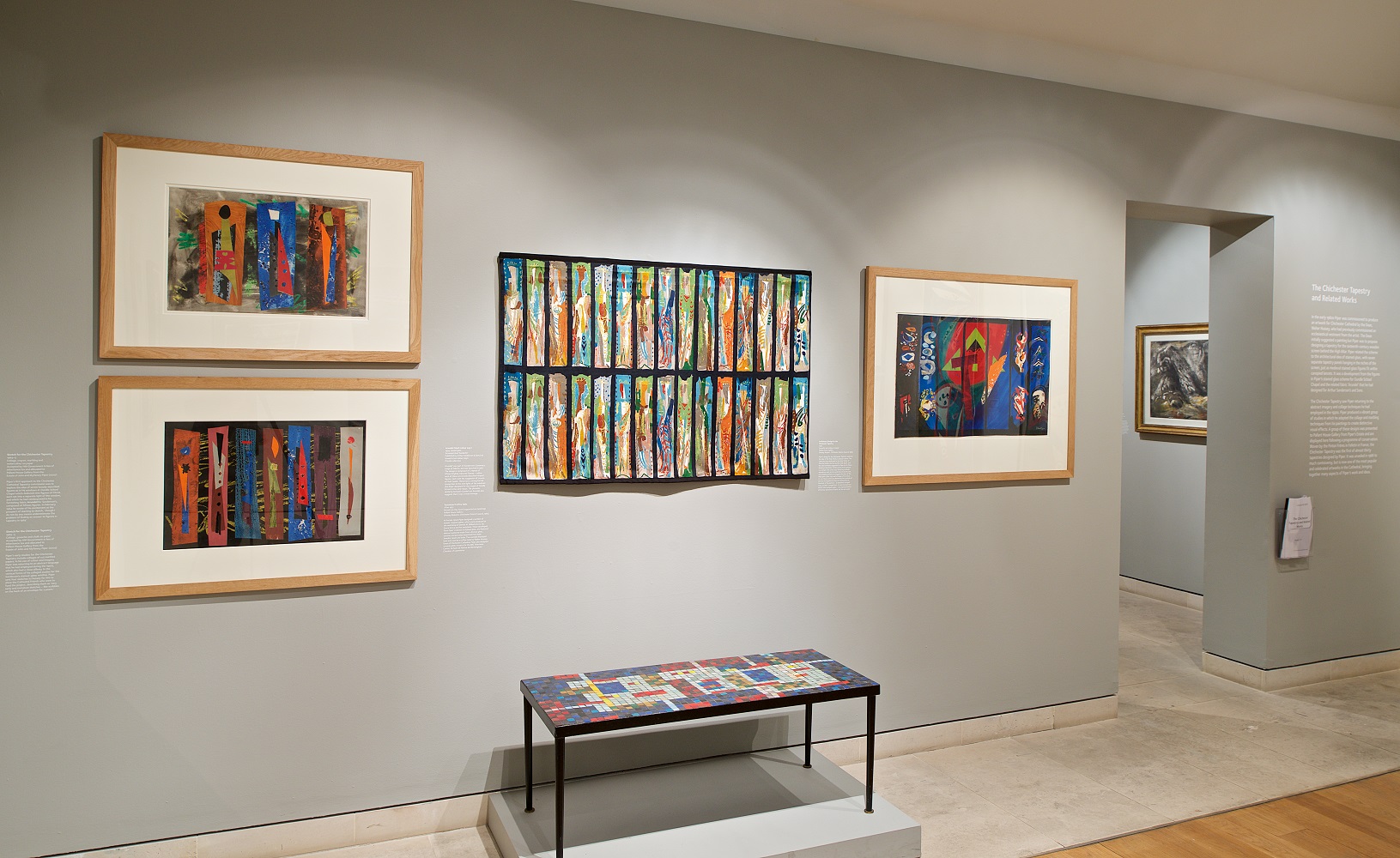 Photograph Mark Heathcote View of gallery showing four abstract wprks of art on the wall with a mosaic table below